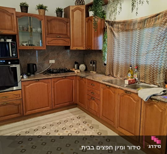 מטבח עם ארונות עץ, כיור ותנור אפייה